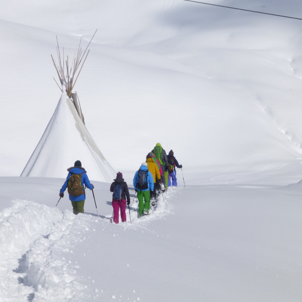 Ein Gruppe läuft mit den Schneeschuhen durch den Neuschnee