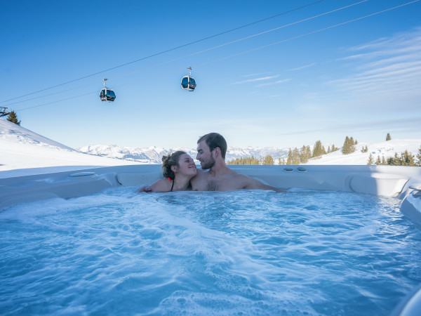 Zwei Verliebte geniessen den Whirlpool im Iglu-Dorf