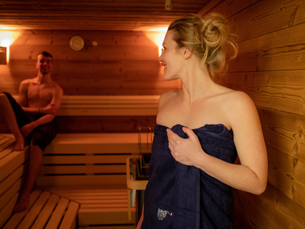 Frau und Mann geniessen einen Saunagang im Iglu-Dorf