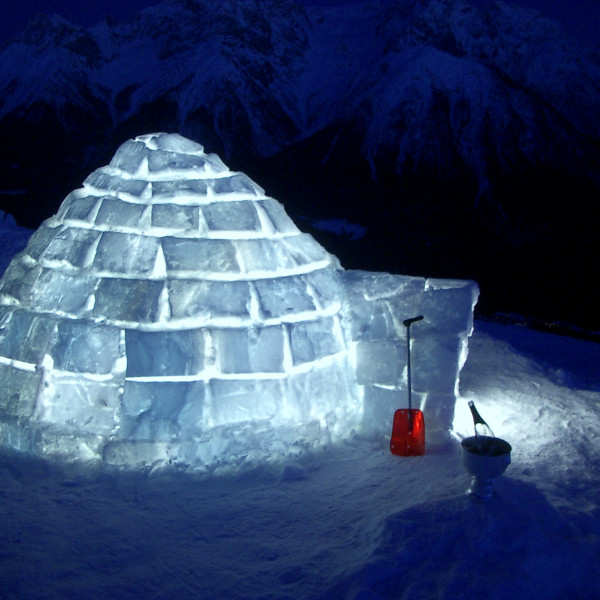 Ein klassisch, selber gebautes Iglu leuchtet in der Nacht