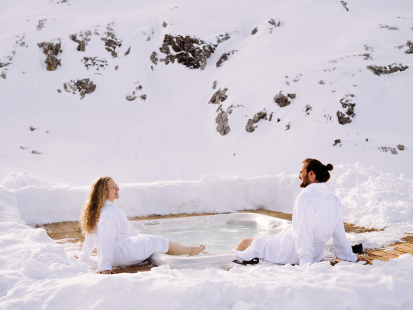 Paar geniesst den Aussenwhirlpool beim Iglu-Dorf