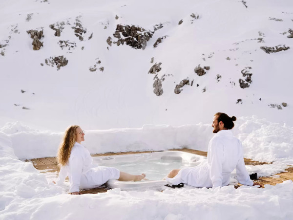Paar geniesst den Aussenwhirlpool beim Iglu-Dorf Davos Klosters